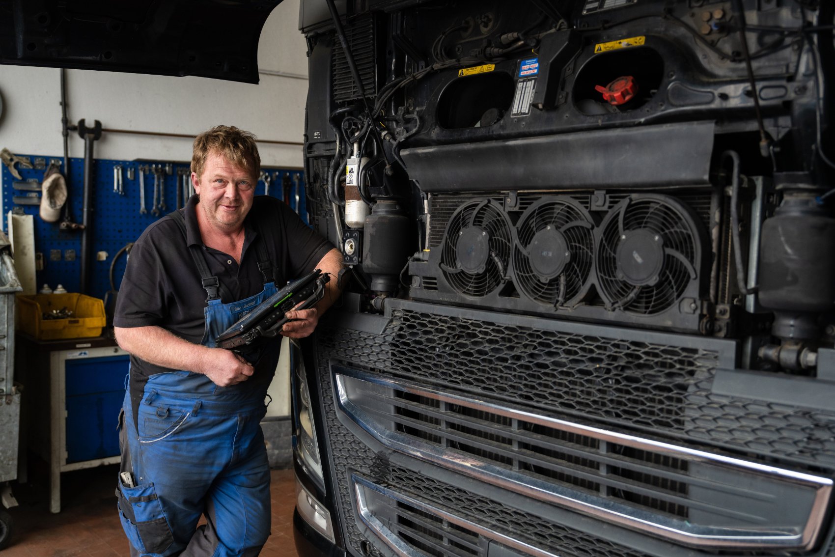 NFZ-Mechaniker mit Diagnosegerät am LKW-Motor